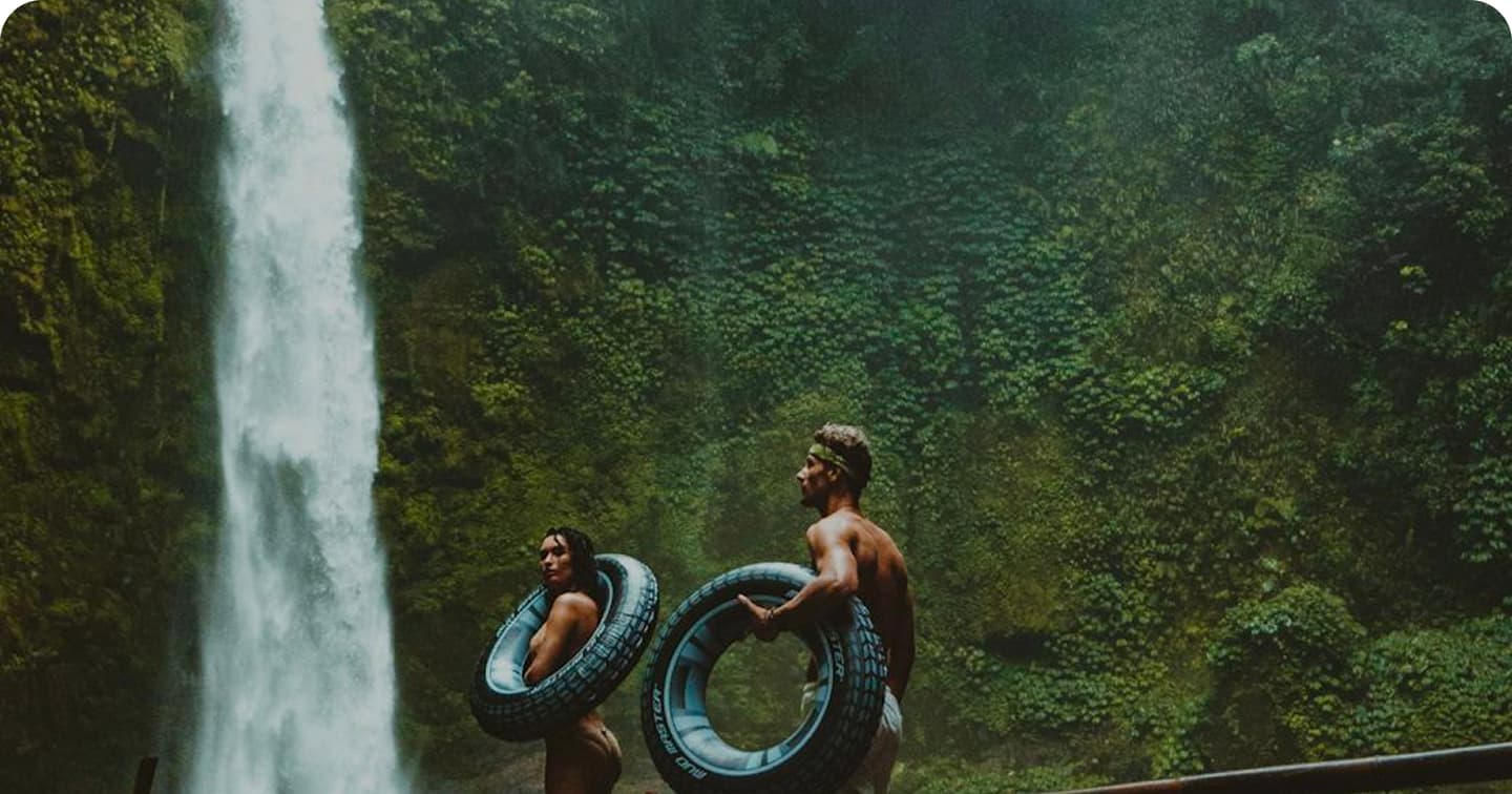 Cascade tropicale avec couple portant des bouées