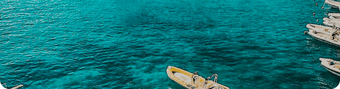 Bateau jaune sur eau turquoise cristalline - inspiration voyage blog INAYA