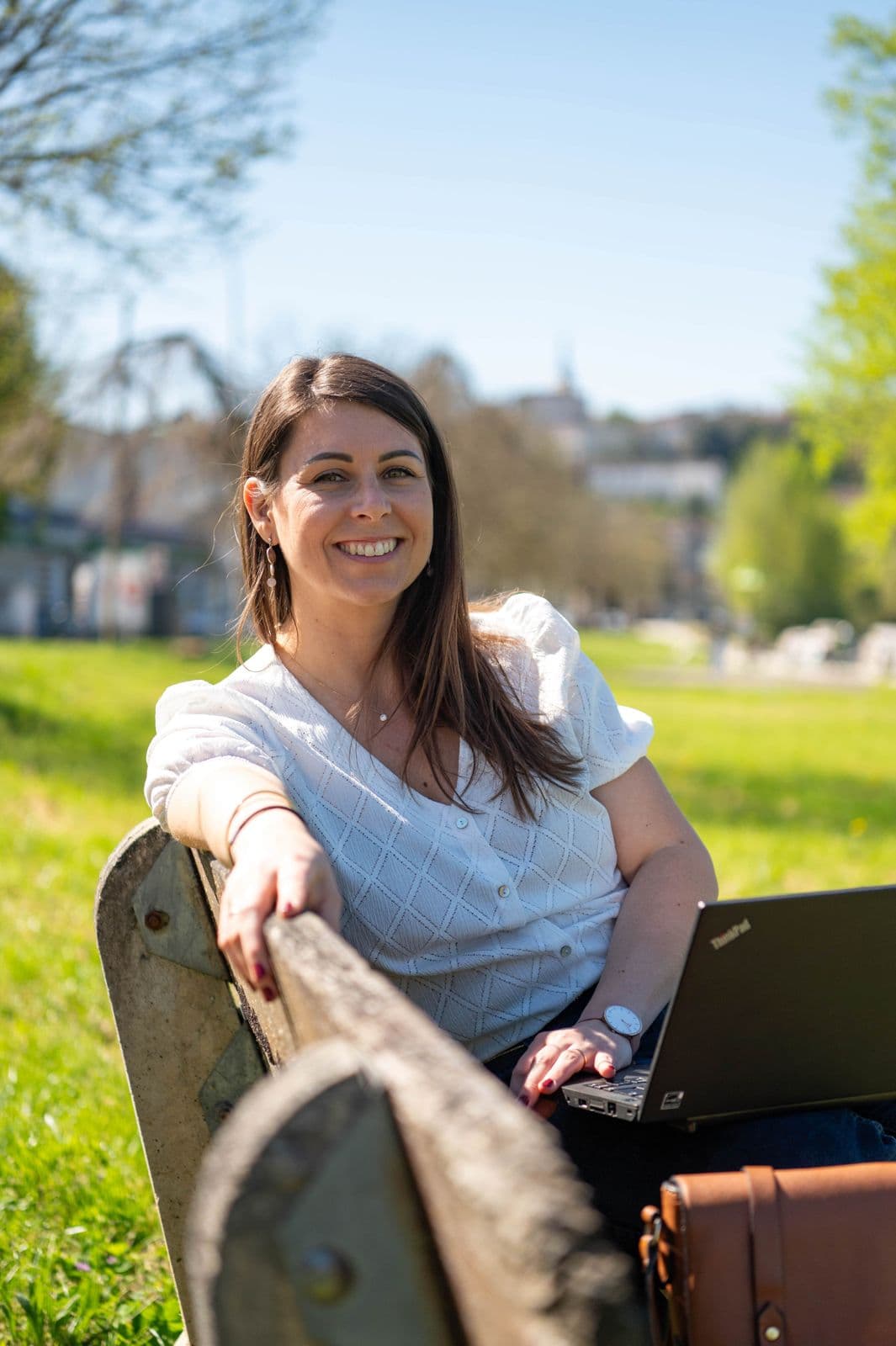 Nathalie, fondatrice d'Inaya, souriante avec des lunettes dans un environnement urbain
